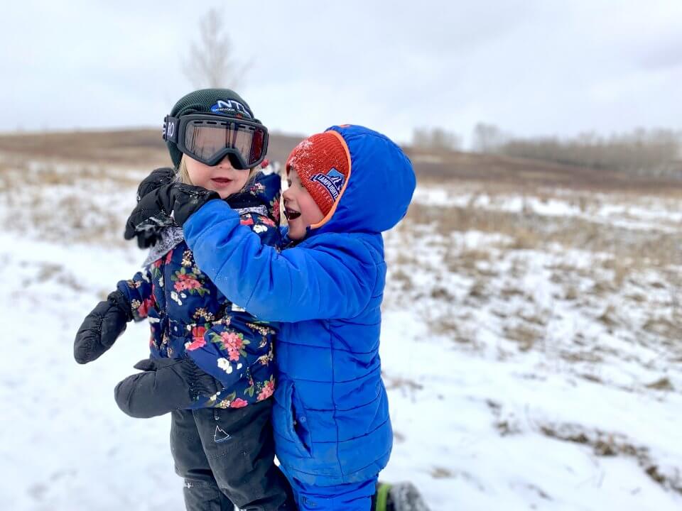 Two children playing outdoors in the winter