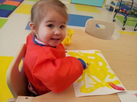 Child painting with yellow paint