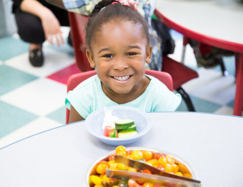 Child smiling eating healthy snack