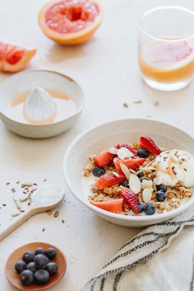 White table with breakfast - yogurt, granola, grapefruit