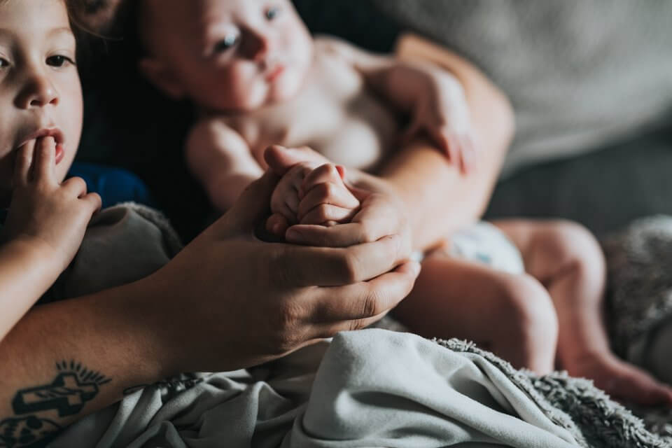 Family with baby and toddler, holding hands