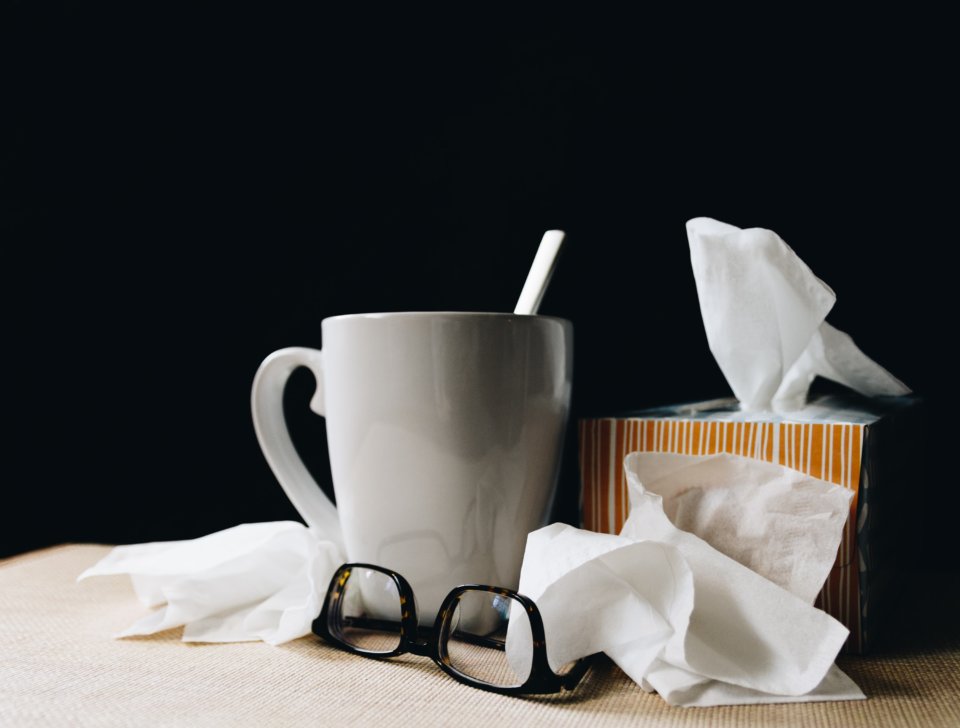 Mug of tea with tissues and glasses