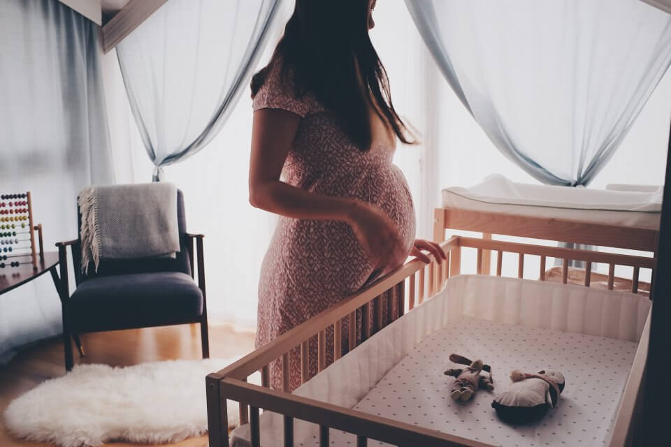 Pregnant mother preparing crib for her baby