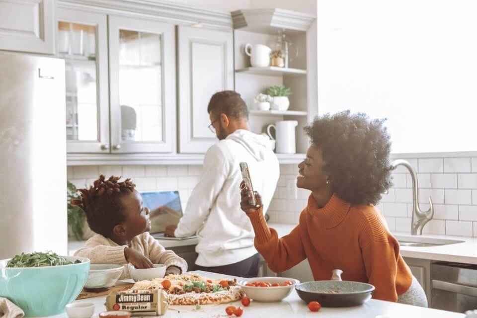 Family of three in the kitchen taking a photo