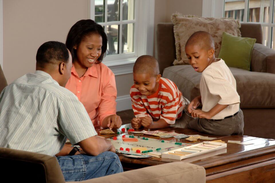 Family of four playing a board game together