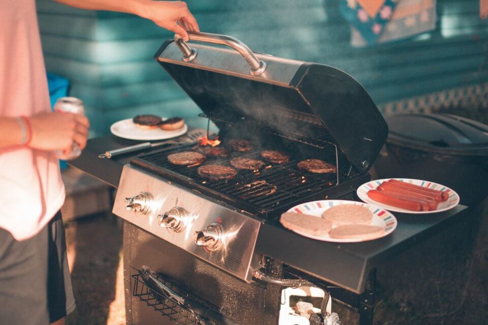 cooking hotdogs and burgers on a barbeque 