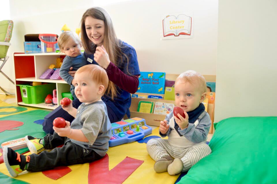 Three children and their teacher playing with musical toys