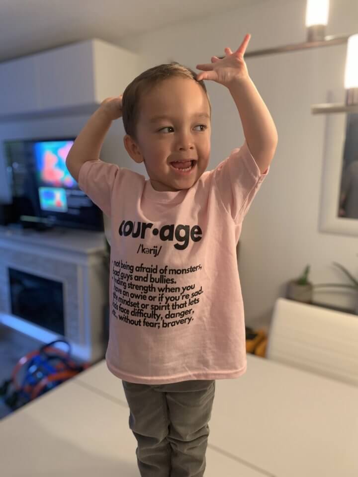 Jaxsen from BC wearing a shirt with the word "courage" on it to support anti-bullying.