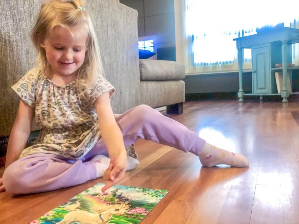 Child doing a puzzle with a unicorn on it