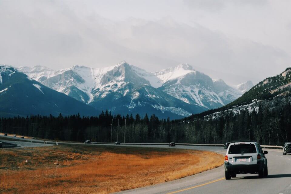 Car on a road trip, driving towards mountains