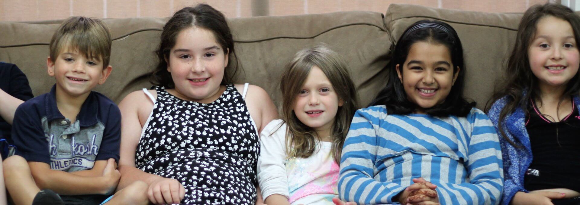Children smiling on couch