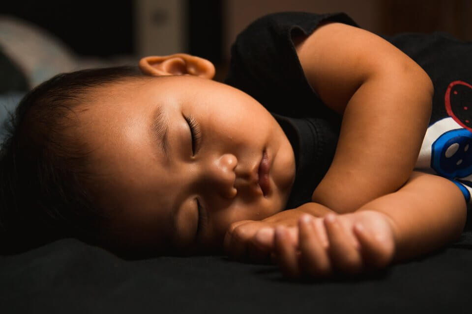 toddler taking a naptime on black sheets