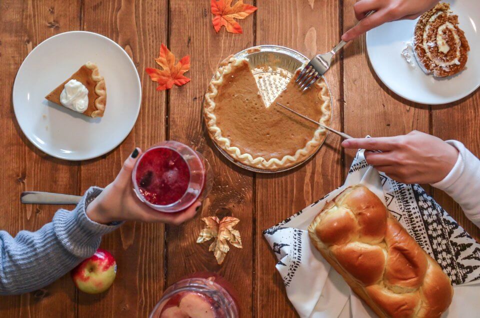 Thanksgiving celebration with pumpkin pie, apples, and bread.