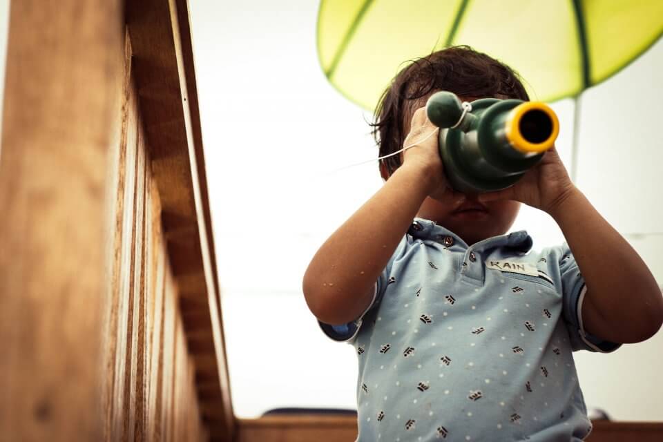 toddler looking through a telescope