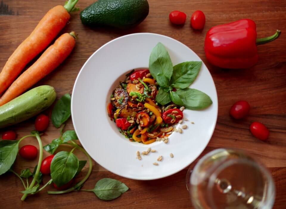 Vegetarian dish on a white plate surrounded by vegetables